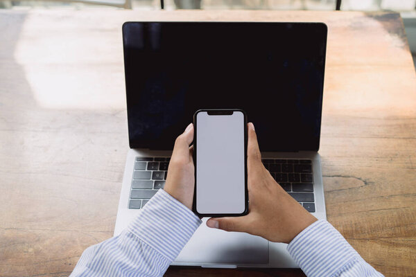 Hands of a businessman using a smartphone mockup at his desk, Mobile phone blank screen for editing graphics.