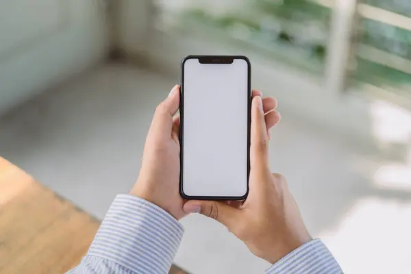 Boş masaüstü ekran ile siyah cep telefonu tutan bir adamın görüntüsü 