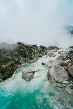 Bir volkanın açık mavi sıcak sülfür suyu akıntısı