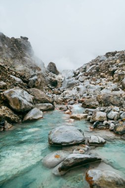 Kaplıcalardan yükselen buhar dağ yamaçlarının üstündeki gökyüzüne yükseliyor..