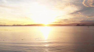 Açık denizde gün batımının muhteşem görüntüsü, Karayipler 'deki okyanus ufkunun ötesinde, yukarıda sarı gökyüzü, dalgalara yansıyan güneş ışığı. yaz arkaplanı ve yaz tatili konsepti.