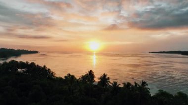 Günbatımı arkaplanının hava görüntüsü. Denizin üzerinde akşam gökyüzü bulutları olan havadan dramatik altın rengi günbatımı. Gökyüzü manzarası