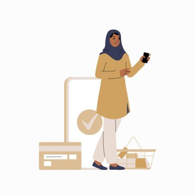 Başörtüsü takan Müslüman bir kadın alışveriş sepetinin yanında dururken cep telefonunu kullanıyor. İllüstrasyonda temassız ödeme ve modern alışveriş deneyimleri vurgulanıyor.