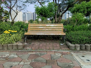 Parktaki bankta gökdelen arkaplanı.