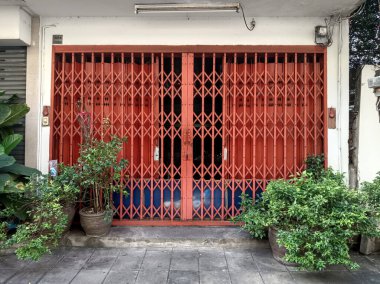 Koyu turuncu kepenkli beyaz duvar.