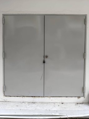 Beyaz duvardaki büyük gri kapı.