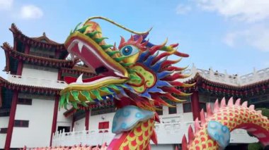 Kuala Lumpur, Malezya 'daki Thean Hou Tapınağı' nda Çin ejderhasının yakın çekimi. Geleneksel Çin çatılı ve arka planında kırmızı fenerler bulunan Güneydoğu Asya mimarisi.