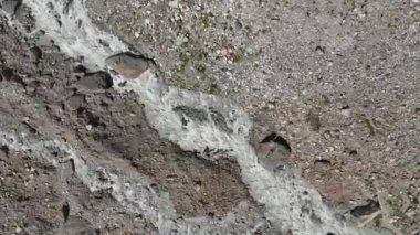 Gürcistan 'ın Svaneti bölgesi yakınlarındaki Mestia, Svaneti Dağları' ndaki görkemli Kafkas Dağları 'ndaki kayalık kıyıları ile Chalaadi Buzulu' ndan doğan öfkeli Mestiachala nehrinin havadan görünüşü.