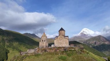 Gürcistan 'ın Stepantsminda köyü yakınlarındaki Kafkasya Dağları' ndaki Gergeti Trinity Kilisesi 'nin hava manzarası. Kazbek Dağı ve karla kaplı görkemli tepeler.