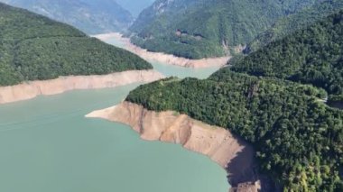 Gürcistan 'ın Svaneti bölgesindeki Inguri nehri üzerindeki ağaçlık tepelerin ve Jvari rezervuarının havadan görüntüsü. Kafkasya Dağları 'ndaki turkuaz gölü ile doğal yeşil manzara.