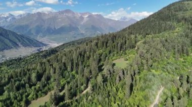 Gürcistan 'ın Svaneti bölgesindeki ağaçlık tepeler, Ushba zirveleri ve Chalaadi Buzulu ile Majestic Kafkasus Dağları' ndaki Mestia kasabasının gökyüzü manzarası..