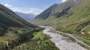 Gürcistan 'ın Svaneti bölgesinde Ushguli köyü yakınlarındaki Enguri nehir boğazı. Kafkasya Dağları 'nın yeşil tepeleriyle çevrili taşlı nehir kıyılarıyla öfkeli bir akıntı..