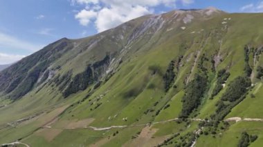 Bulutlu bir günde Gürcistan 'ın Svaneti bölgesinde Ushguli köyü yakınlarında yeşil çimlerle kaplı Kafkas Dağları..