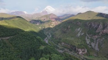 Kafkasya dağlarının ortasındaki Chkheri nehrinin havadan görünüşü Kazbek Dağı 'na, her iki tarafında da Gürcistan' daki Stepantsminda yakınlarında görkemli zirveler var..
