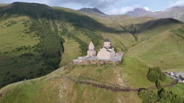 Kafkasya Dağları 'ndaki Gergeti Trinity Kilisesi' nin arka planda Kazbek Dağı ve Gürcistan 'ın Stepantsminda köyü yakınlarındaki görkemli karla kaplı zirveleri..