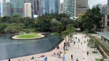 Kuala Lumpur, Malezya - 05.21.2024: Gökdelenleri ve KLCC parkı ile Petronas İkiz Kuleleri yakınlarında bir göl manzarası.