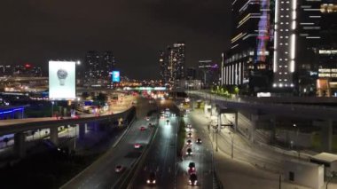Kuala Lumpur, Malezya - 05.26.2024: Günümüz metropolünde hareket eden araçlarla aydınlanan şehir ve otoyolların yükselen hava manzarası.
