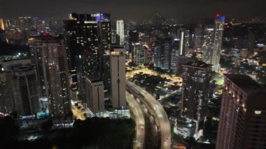 Kuala Lumpur, Malezya - 05.21.2024: Modern metropoldeki karayolu ve gökdelenlerle aydınlatılmış şehir merkezinin havadan görünüşü.
