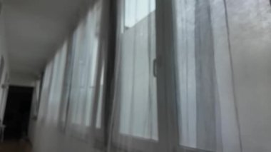 Güzel, sessiz bir koridorda yumuşak bir sabah beliriyor. Orada ışık, perdelerin arasından usulca çağlayarak ruhani bir atmosfer yaratıyor. Düz duvarlar ve geniş duvarlarla kaplı sakin bir yer.