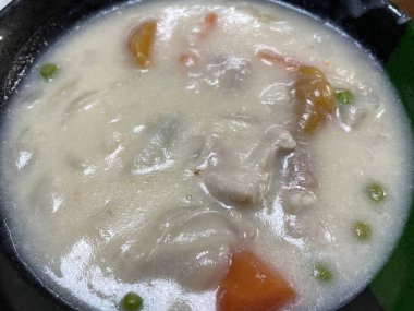 İçi patates, havuç ve etle dolu doyurucu bir güvecin yakın çekimi. Yükselen buhar sıcaklığı ve sade bir atmosferi çağrıştırıyor..