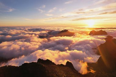 Madeira Adası, muhteşem gün batımı ve bulutlardaki dağlar.