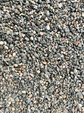 Küçük gri çakıl taşlarının yakın çekimi, gösterişli doku. Doğal desenleri, taşları ve organik elementleri vurgulayan arka plan, doğa temaları veya tasarımlar için mükemmel.