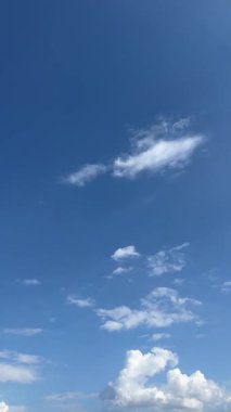 Beyaz bulutların sürüklendiği mavi gökyüzünün dikey videosu. Arka plan, yaz manzarası, hava, doğa, gökyüzü manzarası ve barışçıl atmosfer için ideal.