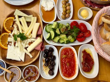 Peynir, zeytin, bal, yağ ve sebzeli geleneksel Türk kahvaltısının dikey fotoğrafı. Renkli bir Türk mutfağı. Yemek, kültür, seyahat ve mutfak temaları için ideal.