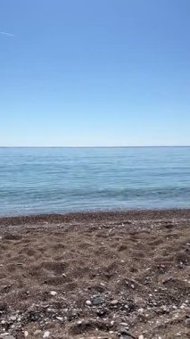 Türkiye 'nin Antalya kentindeki Cirali Plajı' ndaki deniz ve kayalık kıyı şeridinin dikey videosu. Seyahat, doğa, deniz manzarası, kıyı ve Akdeniz temaları için ideal.