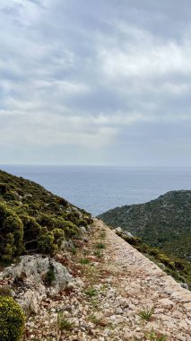 Dikey fotoğraf. Yunanistan 'ın Kastellorizo Adası' ndaki deniz manzaralı deniz manzarası. Yunan kıyı manzarası, Akdeniz manzarası, seyahat yeri, yaz tatili, sakin doğa, deniz manzarası