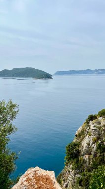 Dağlar ve yeşil tepelerle çevrili bir körfezin dikey fotoğrafı. Akdeniz manzarası, yaz tatili, turizm, doğa, eko-turizm, barışçıl manzara, ilham verici manzaralar, Akdeniz, Türkiye.