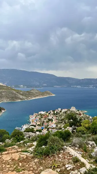Dikey fotoğraf. Yunanistan 'daki Kastellorizo Megisti Adası' nın havadan görünüşü. Yunan ada seyahati, Akdeniz tatili, manzaralı manzara, yaz turizmi, geleneksel evler, kıyı manzarası. 