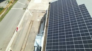 Güneş panelleri binanın çatısına bir açıyla yerleştirilmiş, yan görüş. Videoda ayrıca suyu filtrelemek için kullanılan endüstriyel başlıklar da görülüyor. Hava çekimi güneşli bir havada yapıldı..