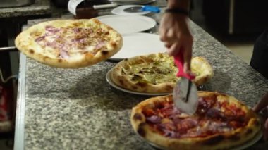 Pizza kesen bir pizzacının elleri..