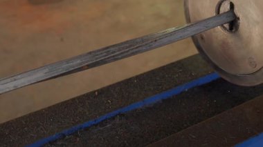 Bükülmüş metal kare çubuk. Çubuk hidrolik torsiyon makinesine yerleştiriliyor ve belli bir hızda dönüyor. Dekoratif ve işlevsel materyal, mimaride ve demircilikte rağbet görüyor..