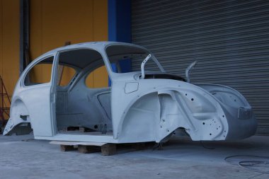 Klasik bir retro arabanın ön gövdesi. Araba restorasyonu. Parçaları ve boyası olmayan bir araba. Klasik, araba tamiratı ve restorasyonu, antika araba, garaj, araba restorasyonu.