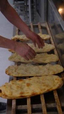 Bir fırıncı taze pişmiş kekleri açar. Sıcak sünger kekinden buhar yükseliyor, tazelik ve sıcaklığı gösteriyor. Profesyonel bir fırında pişirilmiş mallar..