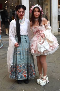 Geleneksel Venedik karnaval kostümlü insanlar Venedik Karnavalı sırasında tarihi bir avluda fotoğraf için poz veriyorlar. Venedik, İtalya 02: 16. 2025