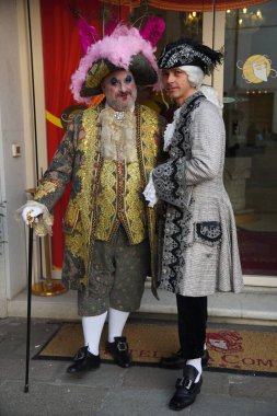 Geleneksel Venedik karnaval kostümlü insanlar Venedik Karnavalı sırasında tarihi bir avluda fotoğraf için poz veriyorlar. Venedik, İtalya 02: 16. 2025