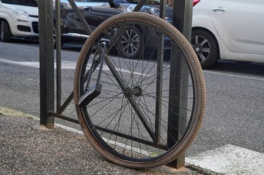 Engellenmiş bisiklet tekerleği. Şehir otoparkında piyango varsa ve kazanamazsan. Görünüşe göre bisiklet Roma 'da başka bir yerde yeni bir hayata başlamaya karar vermiş..