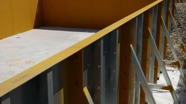 Çelik bir yüzme havuzu inşaatı. Çerçevenin dibi beton ve teknik bir deliği var. Beyaz modüler bloklar yerleştirilerek merdiven ve dinlenme alanları oluşturuldu.