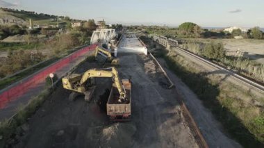 Dağ kıyısında bir köprü inşaatı. Çift amaçlı kemer köprüsünün drone görüntüsü. Deniz kıyısında bir dağ nehri boyunca bir köprü inşa edilecek..