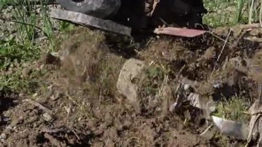 Bir ekiciyle bahçe toprağı sürmek. İnsan eliyle işletilen bir ekici, sebze ekmeye ve fideleri ekmeye hazırlanarak bahçe toprağını gevşetiyor..