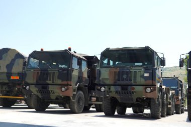 Bir yerde büyük bir askeri ekipman koleksiyonu. Koleksiyonda zırhlı personel taşıyıcılar, tanklar, nakliye kamyonları ve destek birimleri gibi çeşitli ekipmanlar yer alıyor..