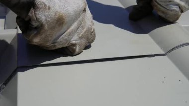 Özellikle endüstriyel beyaz sandviç panelleri için tasarlanmış özel bir sırt kapağı kurulumu. Sırt kapağı perçin ve dolgu maddesiyle tutturulmuştur..