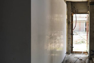 Yeni bir evin alçıtaşı duvarı mükemmel bir şekilde sıvanmış. Modern bir konut projesinde pürüzsüz bir iç kaplama.