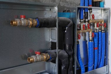 İnşaat halindeki bir eve su ısıtma sistemi kurulması. Modern tesisat ve ısıtma boruları. Evde su kaynağı var. Koleksiyoncu.