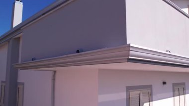 Bir muslukçu, kiremit çatılı yeni yapılmış bir eve alüminyum oluklar ve alüminyum renkli oluklar yerleştirdi. Çatının olukları olmayan bölümleri alüminyum korniş / süsleme ile tamamlanmıştı..