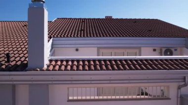 Bir muslukçu, kiremit çatılı yeni yapılmış bir eve alüminyum oluklar ve alüminyum renkli oluklar yerleştirdi. Çatının olukları olmayan bölümleri alüminyum korniş / süsleme ile tamamlanmıştı..