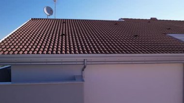 Bir muslukçu, kiremit çatılı yeni yapılmış bir eve alüminyum oluklar ve alüminyum renkli oluklar yerleştirdi. Çatının olukları olmayan bölümleri alüminyum korniş / süsleme ile tamamlanmıştı..